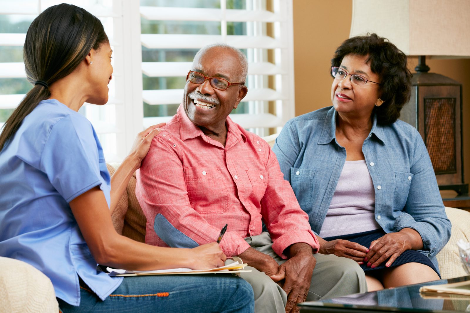 A caregiver talking with a senior couple at home